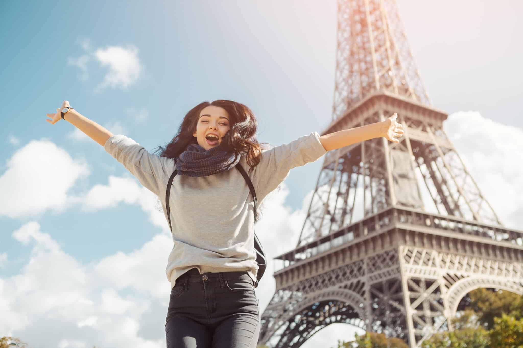 young attractive happy woman jumping joy against eiffel tower paris france